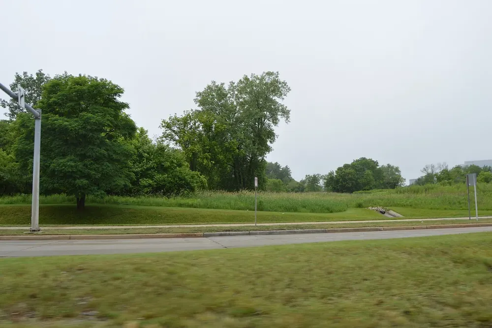 Open grassy land and trees beside State Route 175 in Beachwood, Ohio