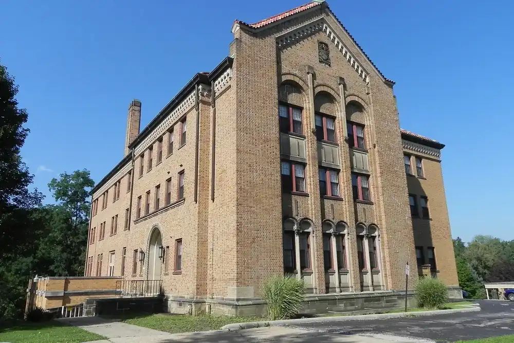 The tall yellow-brick Villa San Bernardo building on a sunny summer day in Bedford, Ohio