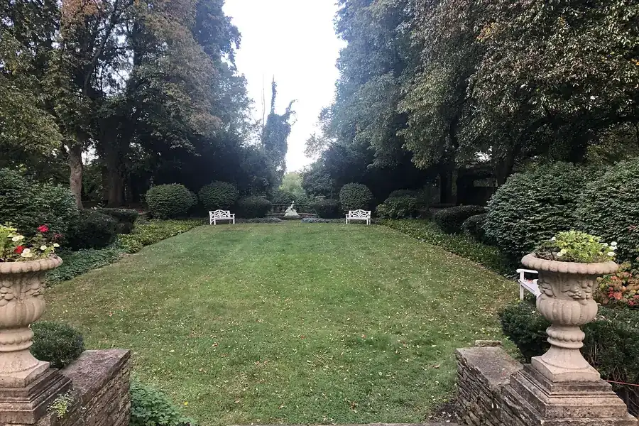 A long formal lawn lined with stone urns and tall shade trees in Concord Township, Ohio