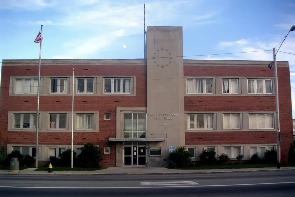 The three-story brick East Cleveland City Hall with its central tower, seen from the street