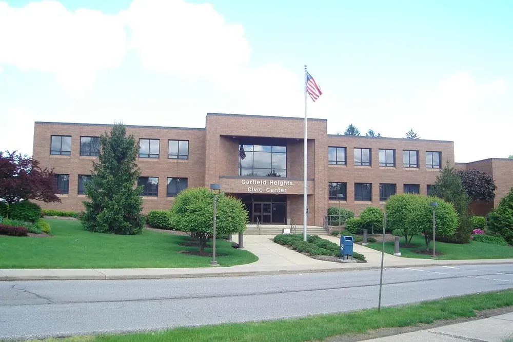 The two-story brick Garfield Heights Civic Center with a flagpole and lawn in front