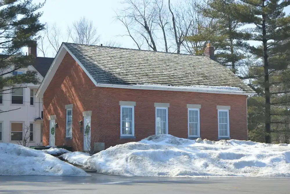 The red brick Old Euclid District 4 Schoolhouse beside winter snowbanks in Lyndhurst, Ohio