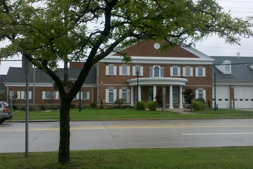 The brick Mayfield Heights city hall with a white columned entrance, seen across the street