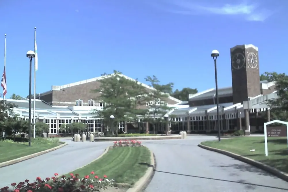The Solon City Hall entrance drive with flower beds and a brick clock tower